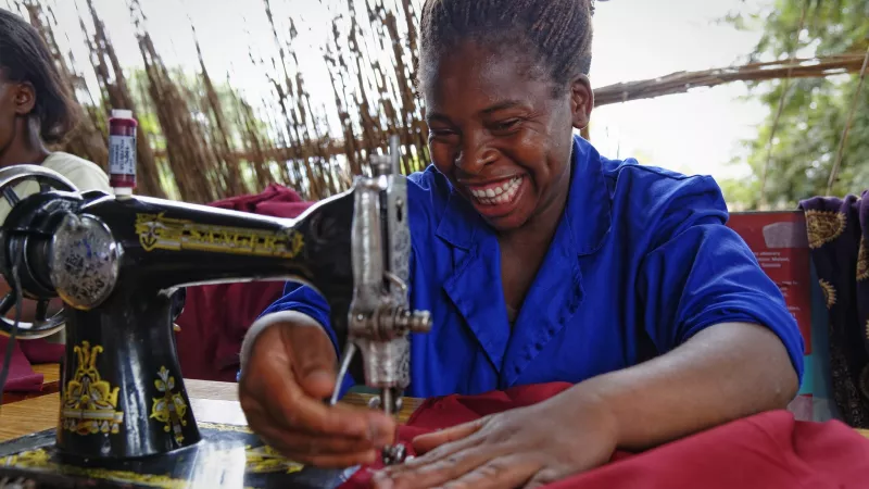 woman working on sewing machine and smiling