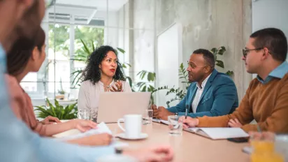 Colleagues brainstorming around an office table