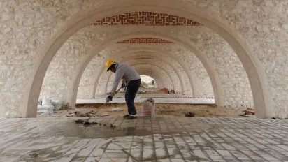 Man working on the flooring of a new marketplace in Tunisia