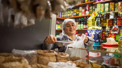 La vendedora detrás del mostrador pesa la mercancía