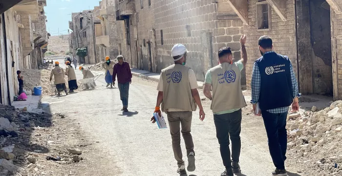 three men walking in the destroyed streets by the earthquake in Syria