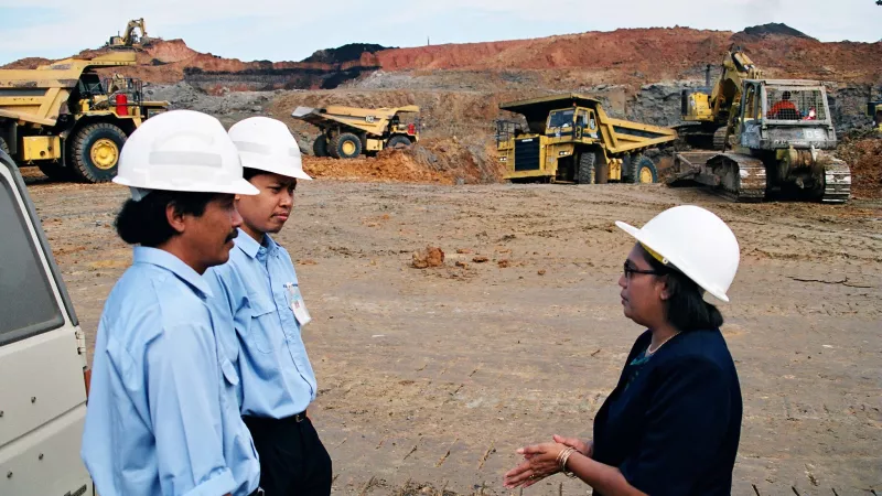 Woman mining worker speaking to colleagues at a mine site in Indonesia. 