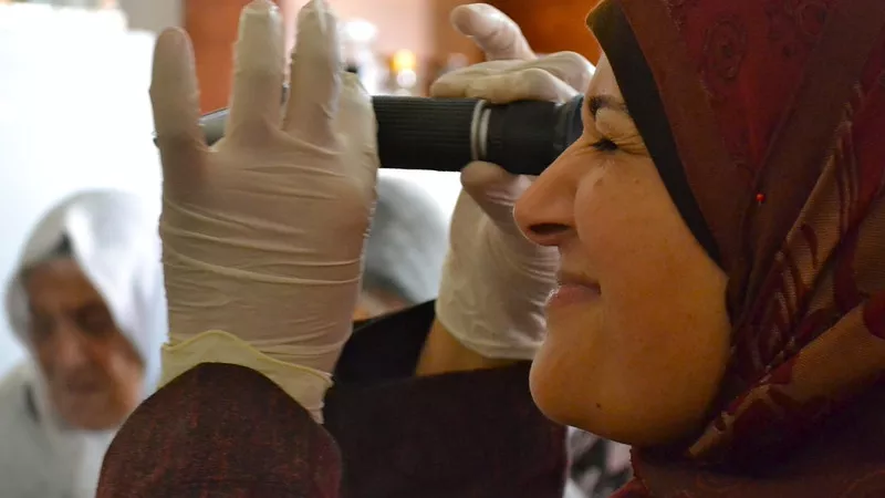 Young woman looking through microscope