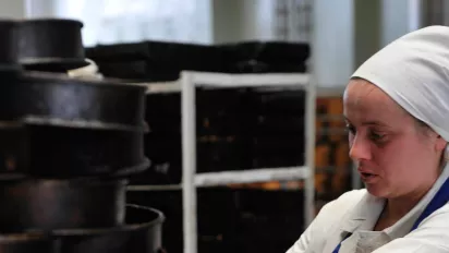 Young worker cleaning cake molds